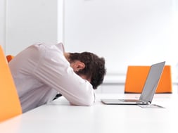 Frustrated young business man have stress problems. Sitting alone at office meeting room  and working on laptop compute.-1