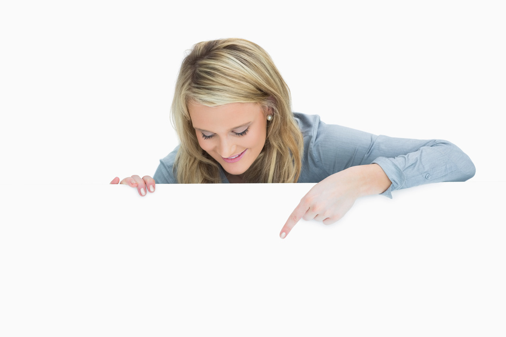 Happy woman pointing down at the poster