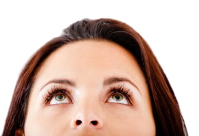 Woman with beautiful eyes looking up - isolated over a white background