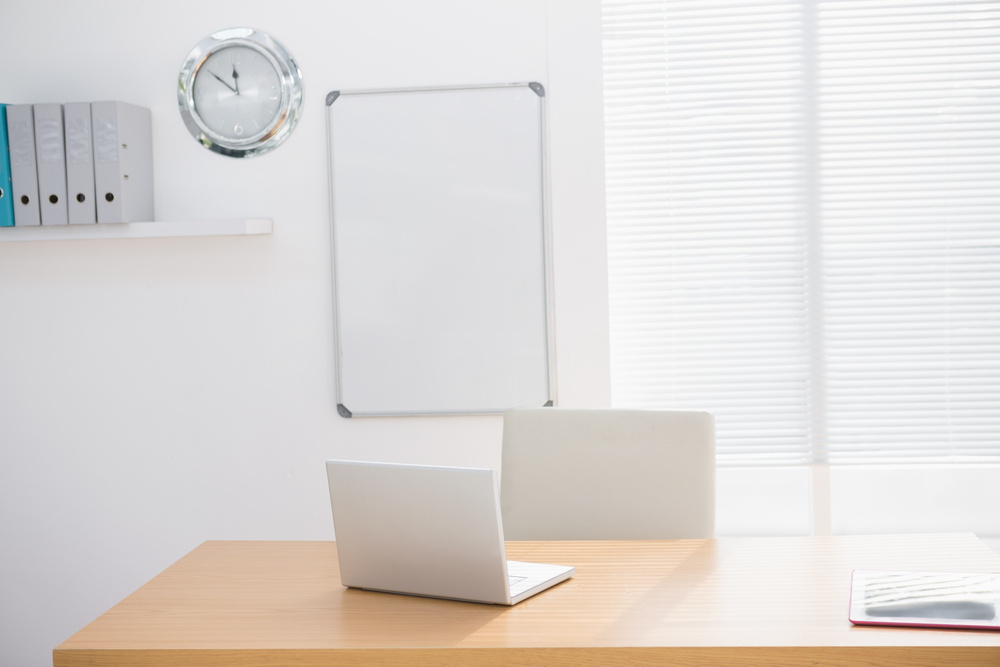 A empty lighted office with a laptop