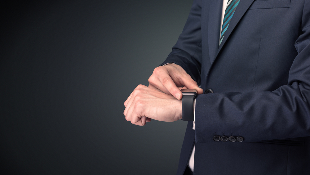 Man wearing suit with smartwatch on his wrist.