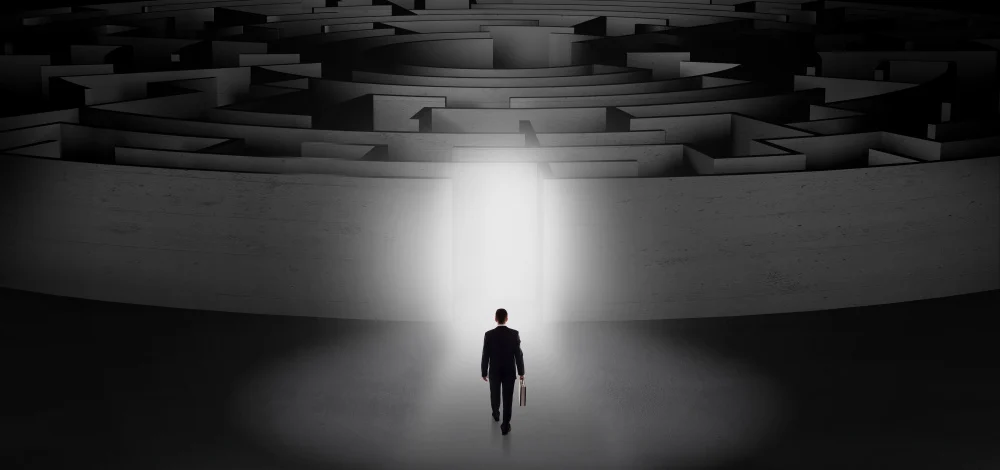 Businessman getting ready to enter a concentric labyrinth with lighted entrance concept