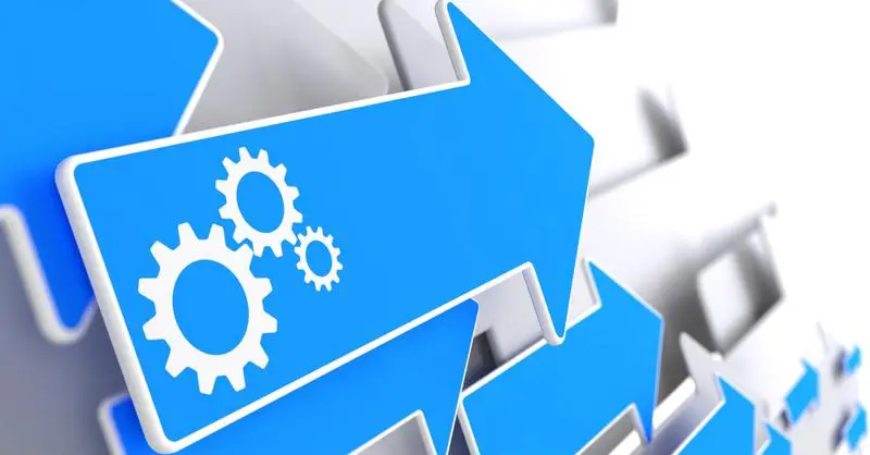 Cogwheel Gear Mechanism Icon on Blue Arrow on a Grey Background