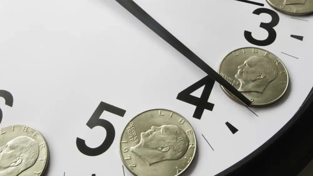Concept of time is money Eisenhower dollar coins on face of analog clock