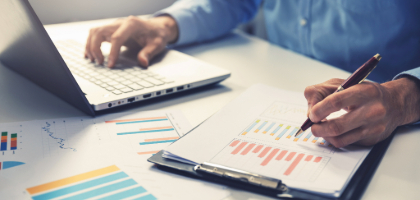 man on computer taking notes