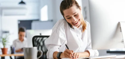 woman on phone and taking notes
