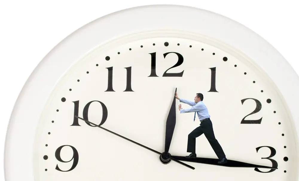 clock hands being pushed back by a business man
