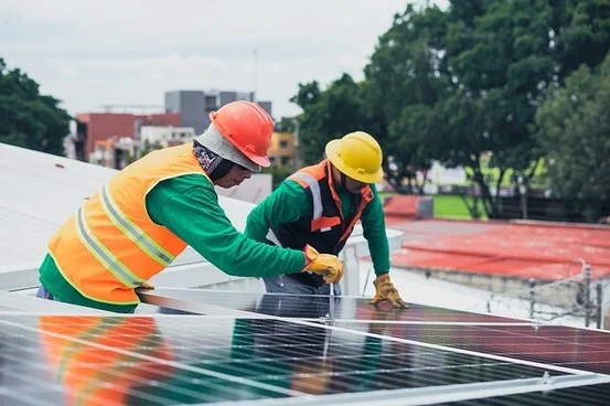 Two Constructions workers installing solar panels