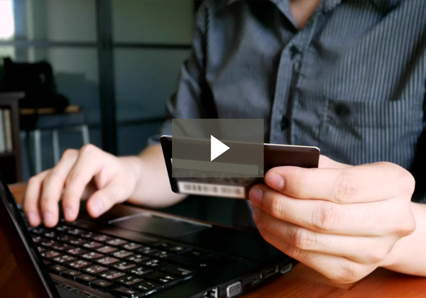man holding credit card in front of laptop video icon