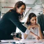 People looking at documents and images on a desk